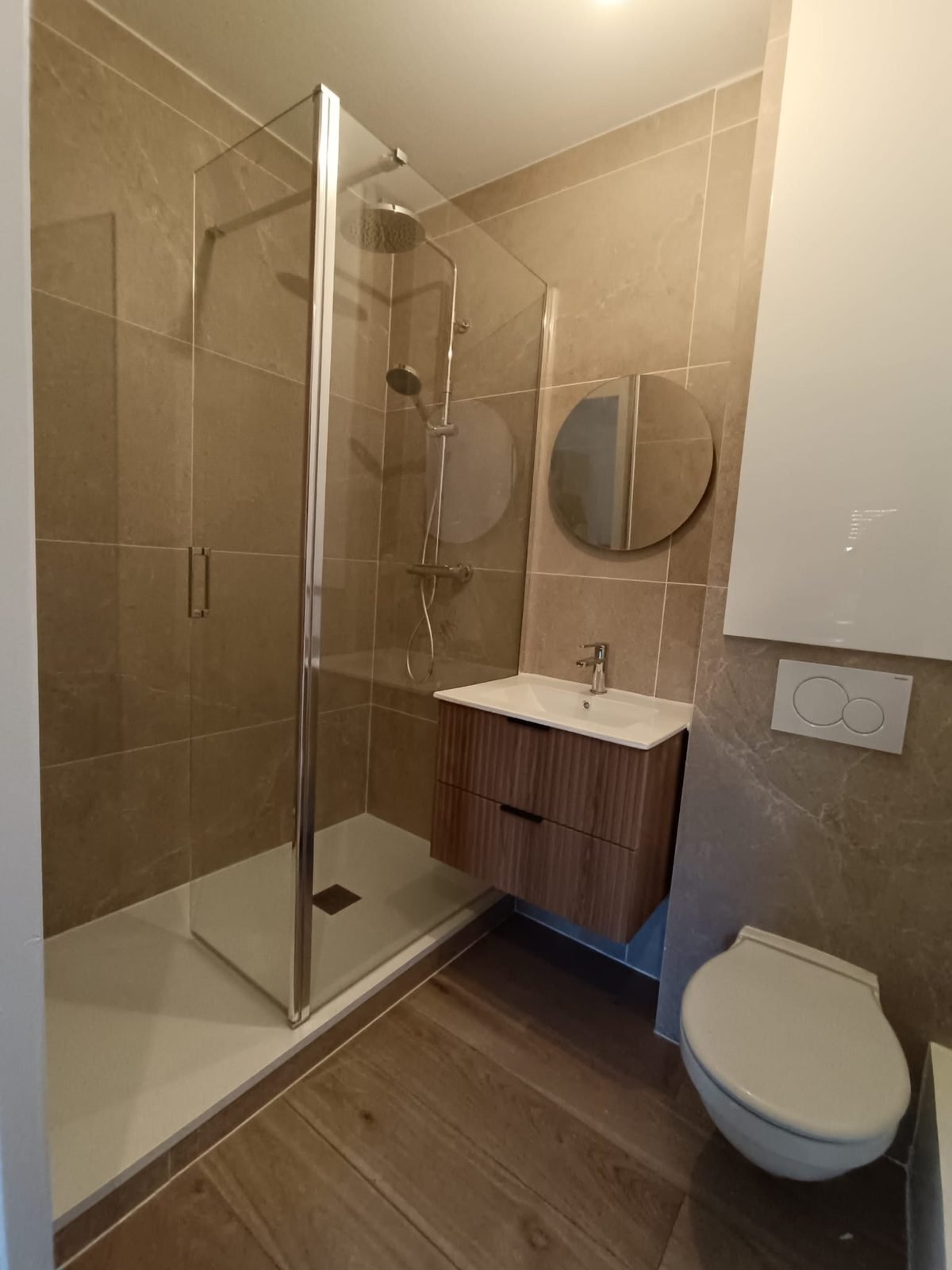 Salle de bain après rénovation par Rénocem Habitat à Nantes — douche italienne, vasque bois, carrelage effet pierre
