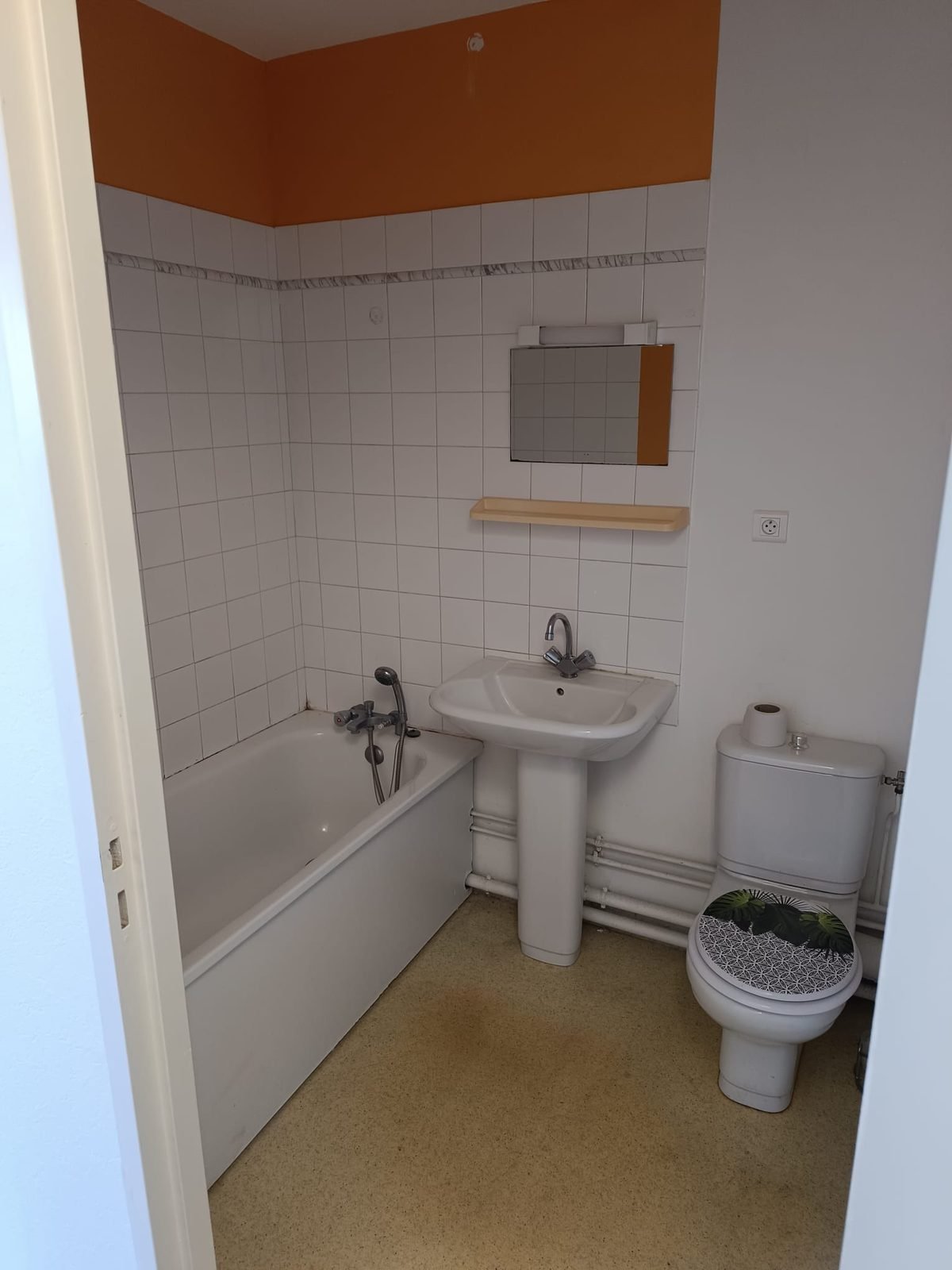 Salle de bain avant rénovation — baignoire ancienne, carrelage daté