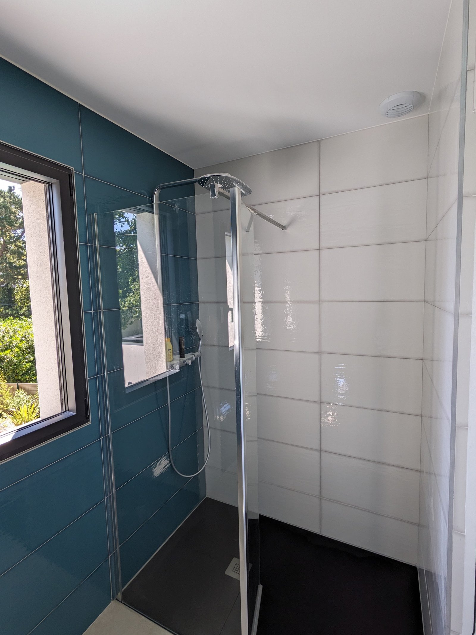 Salle de bain rénovée par Rénocem Habitat — douche italienne avec faïence bleu canard