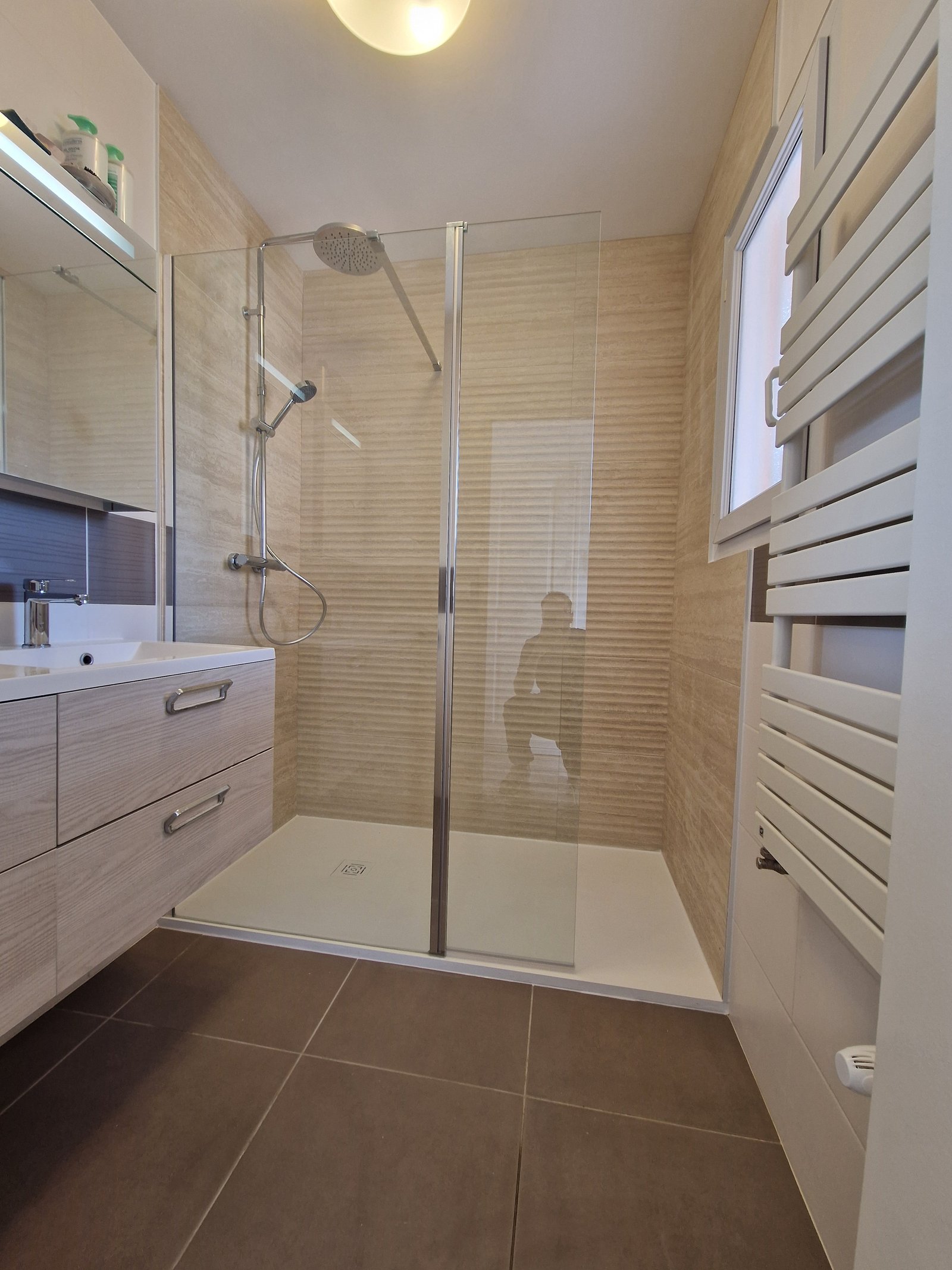 Remplacement d'une baignoire par une douche à Haute-Goulaine — receveur extra-plat, faïence grand format texturée et paroi fixe avec battant